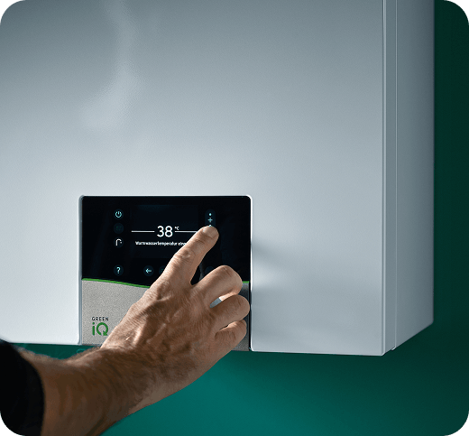 A closeup of a hand adjusting a boiler