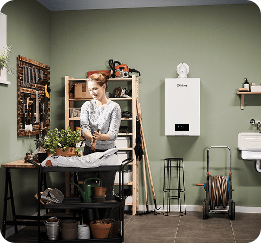 A woman doing an activity at a workbench with a boiler in the background